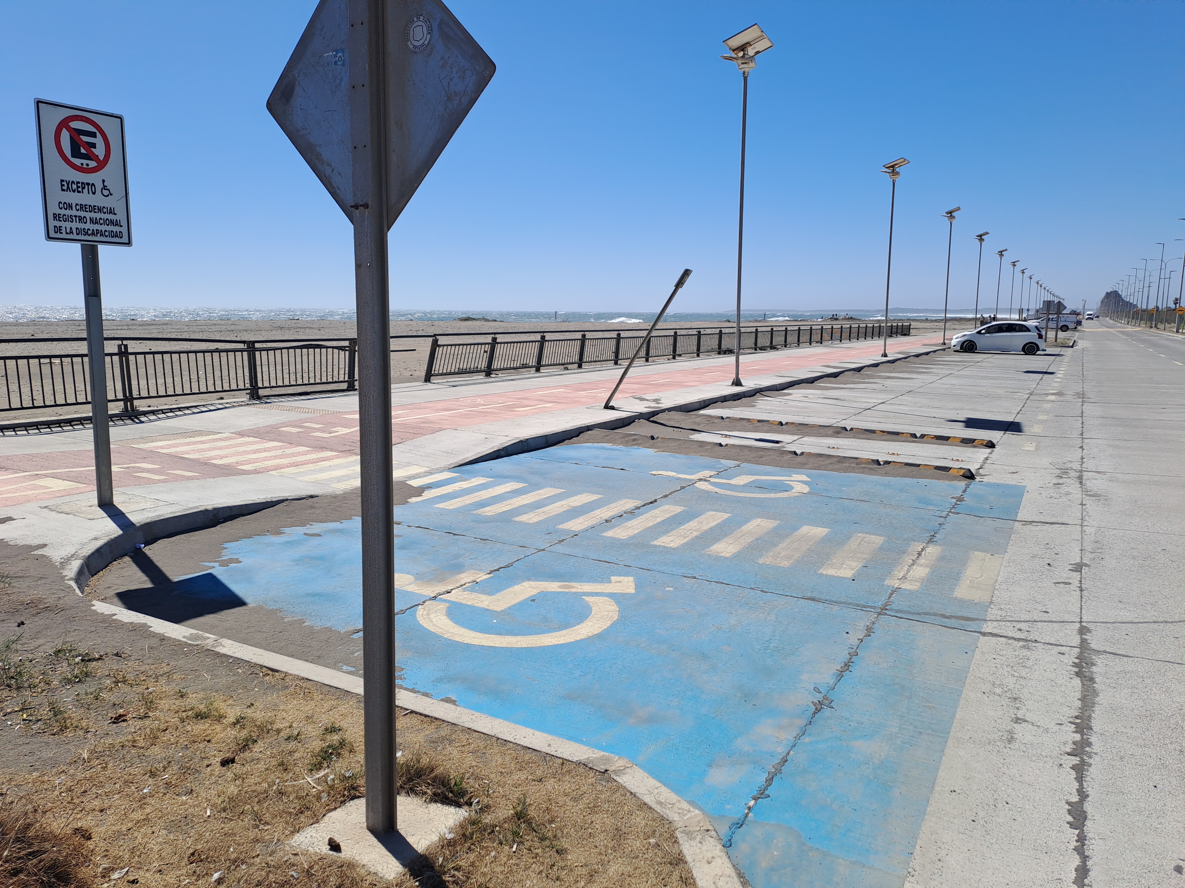 Fotografía del estacionamiento, se destaca un letrero que habilita uso solo a personas con discapacidad